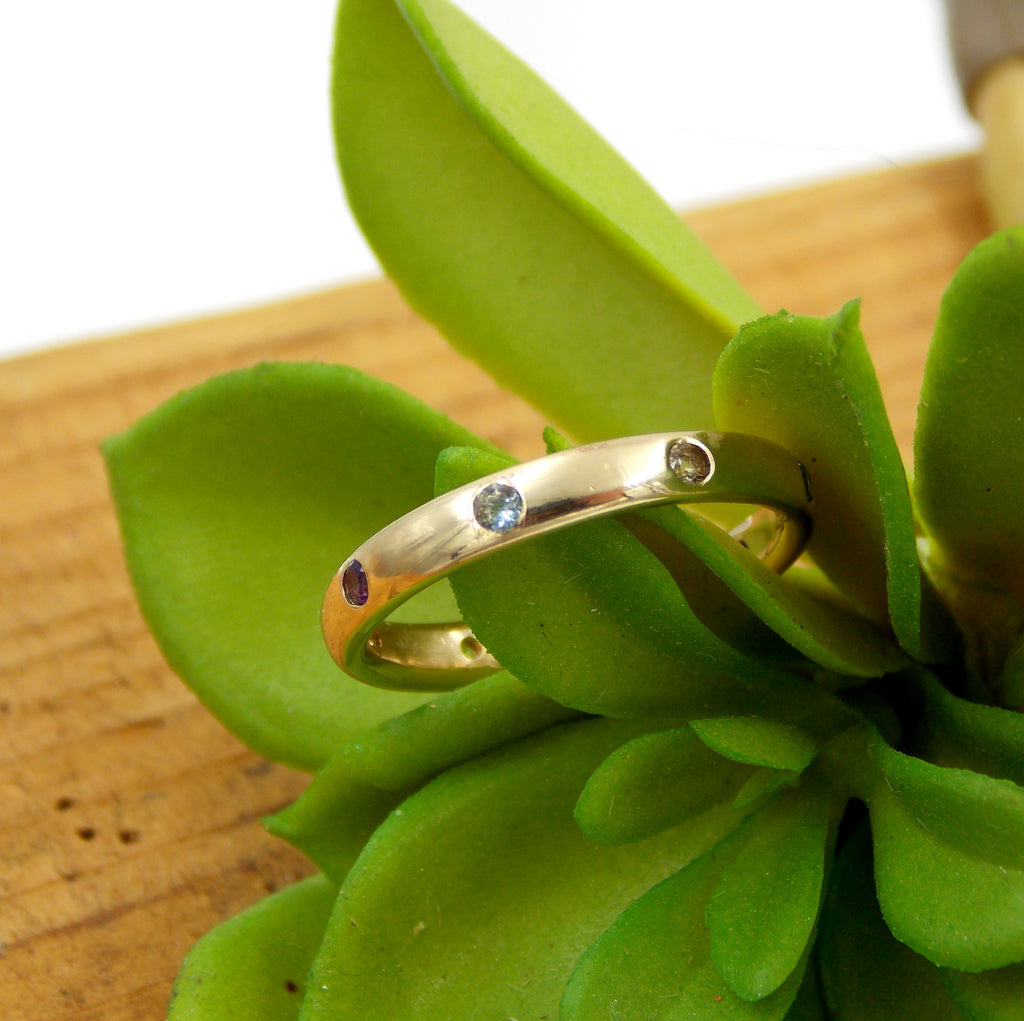 custom solid gold wedding ring with birthstones flush set into the band